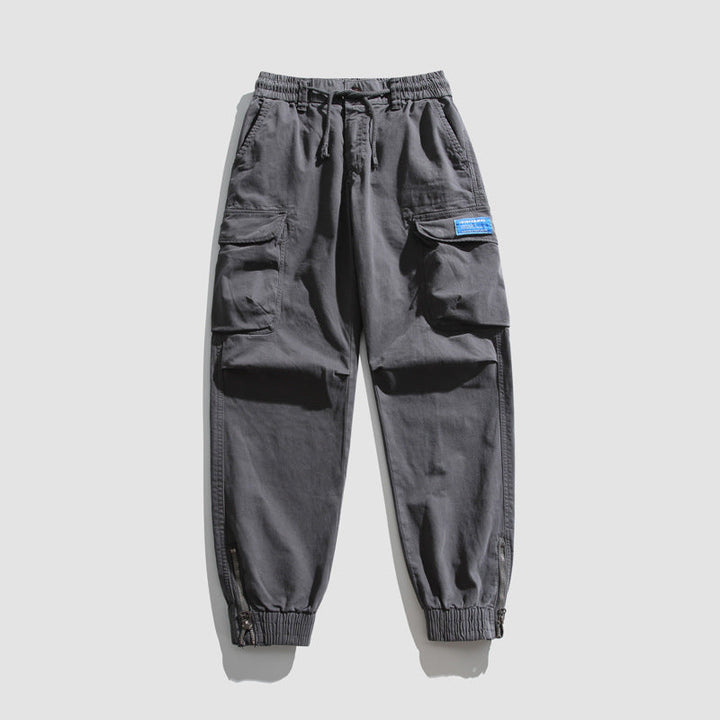 Herren Konisch geschnittene Utility-Cargo-Jogginghose mit Tunnelzugbund, Klapptaschen und Knöchelreißverschlüssen Mune Fashion